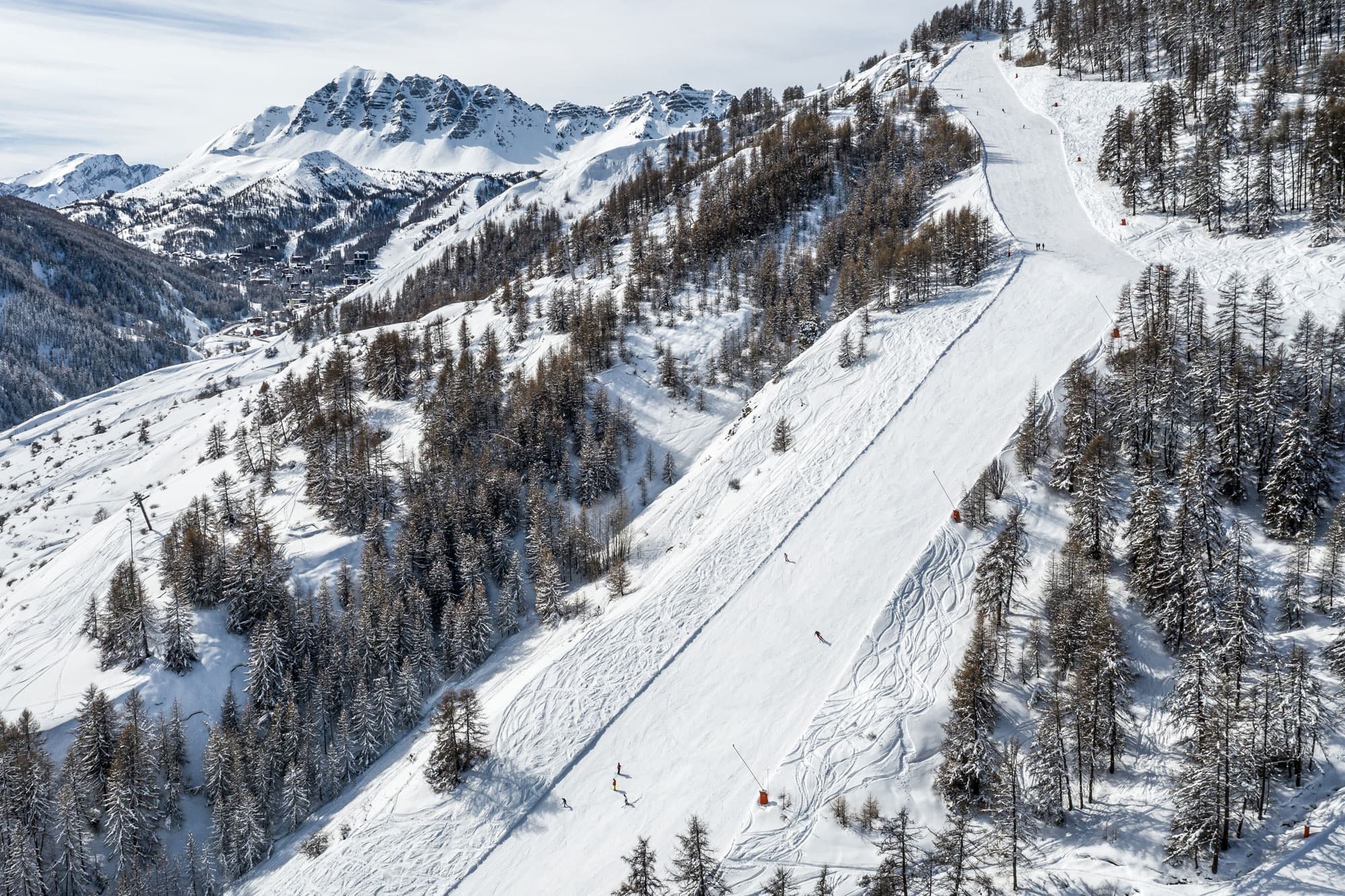 Skiiers enjoying long ski slope in French Alps at Vars ski resort
